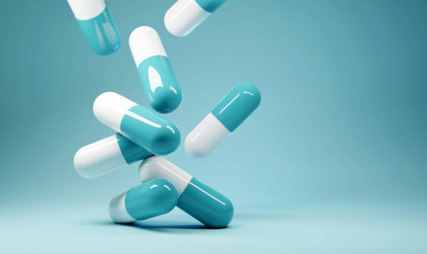 A group of antibiotic pill capsules fallling. Healthcare and medical 3D illustration background.
